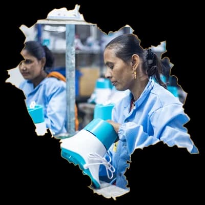 Two team members assembling appliances, framed in the outline of Himachal Pradesh