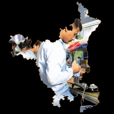 A team member on a production line, framed in the outline of Haryana