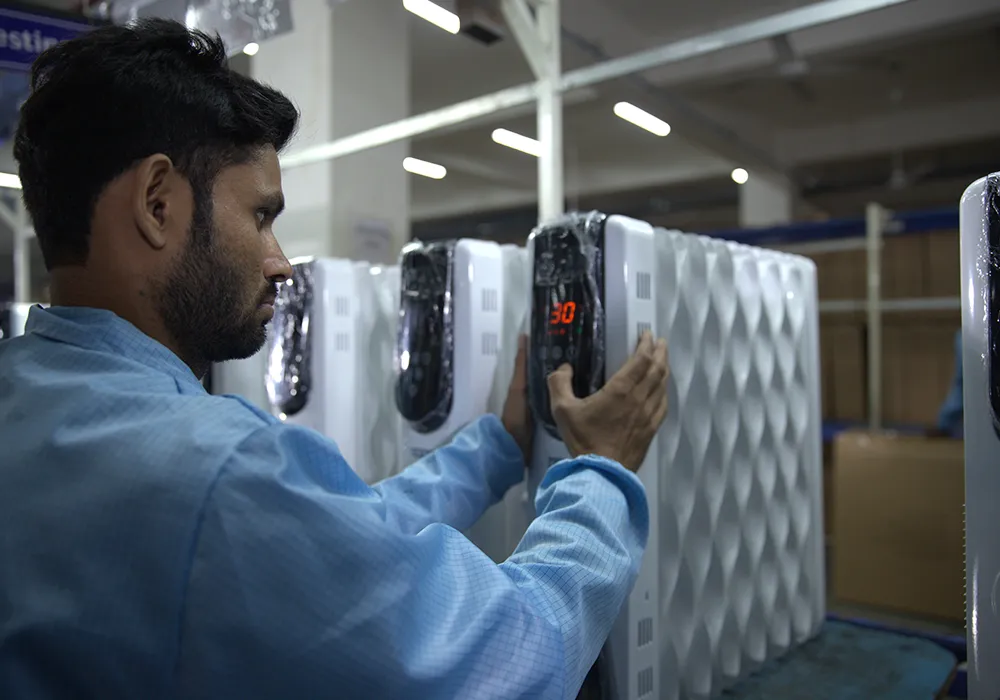 A technician handling an oil-filled room heater