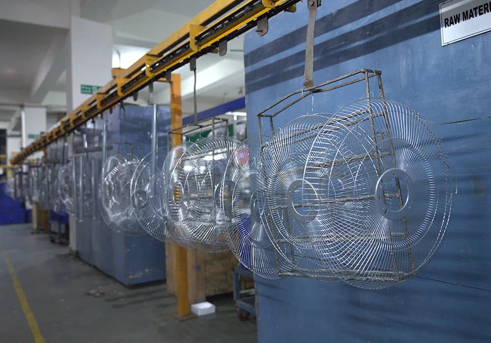 Fan guards hanging on an overhead conveyor in the factory