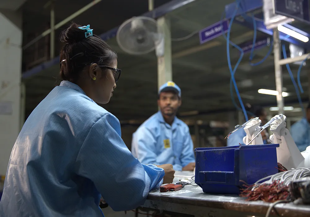 Two team members assembling fan wiring at a workbench