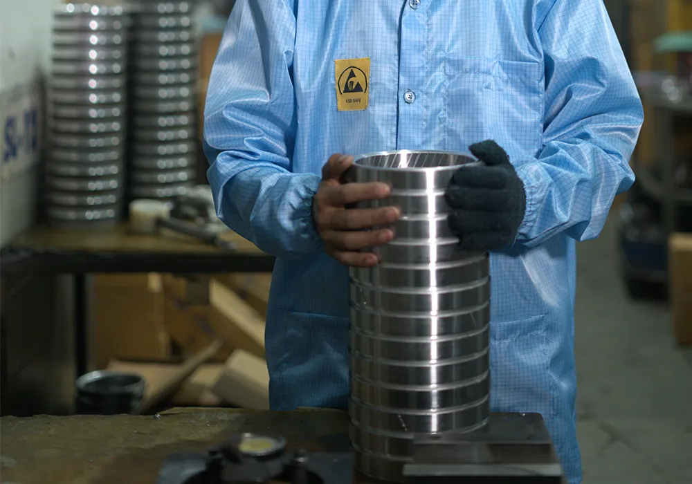 An operator holding a stack of polished steel rings
