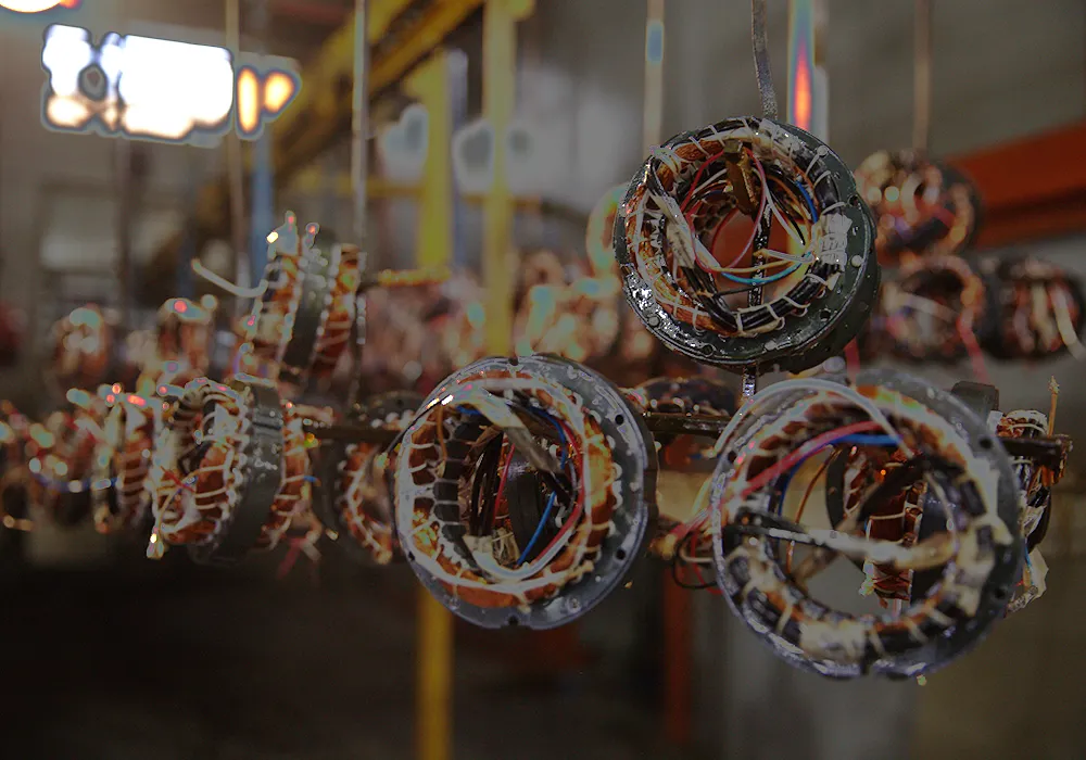 Copper-wound motor stators hanging in a workshop